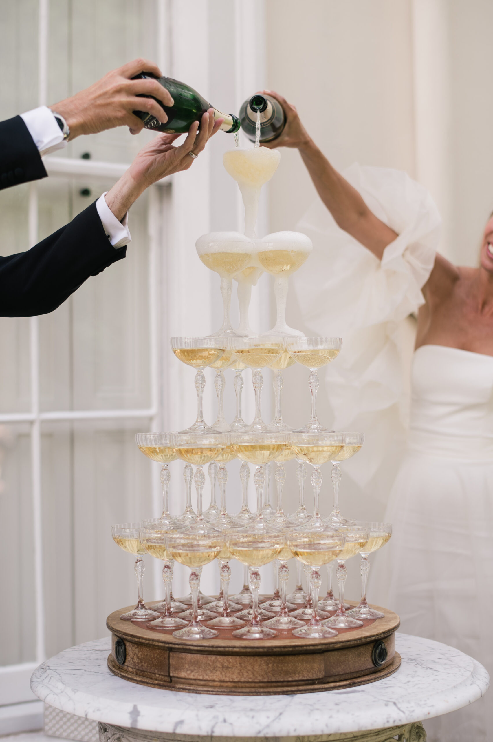 A tower of champagne glasses being filled